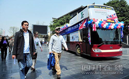 在宽窄巷子，几位外国游客从世博大巴旁经过