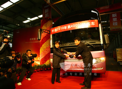 郑州交运集团董事长(左一)与雷勇贴上经典的宇通车标